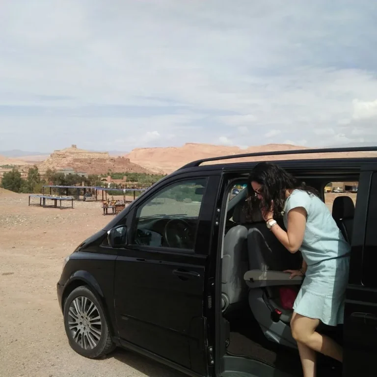 Passenger boarding a private tour vehicle near Ait Ben Haddou